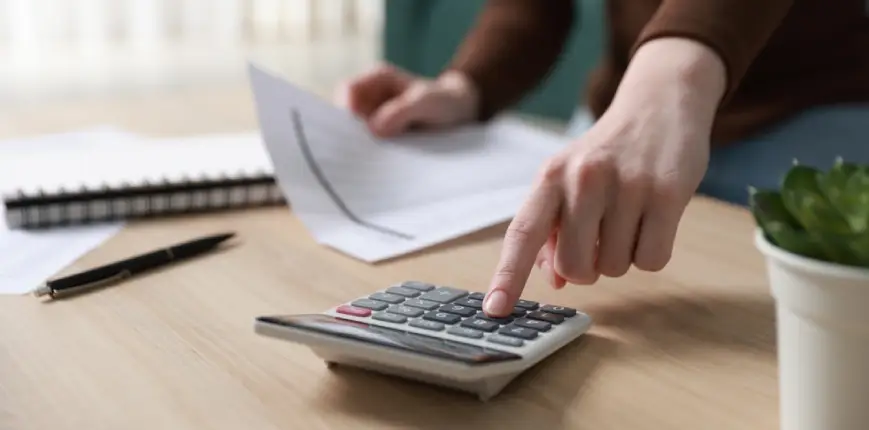 ผู้หญิงกำลังคำนวณค่าใช้จ่ายทริปเที่ยวครอบครัวให้เหมาะสมกับงบประมาณ