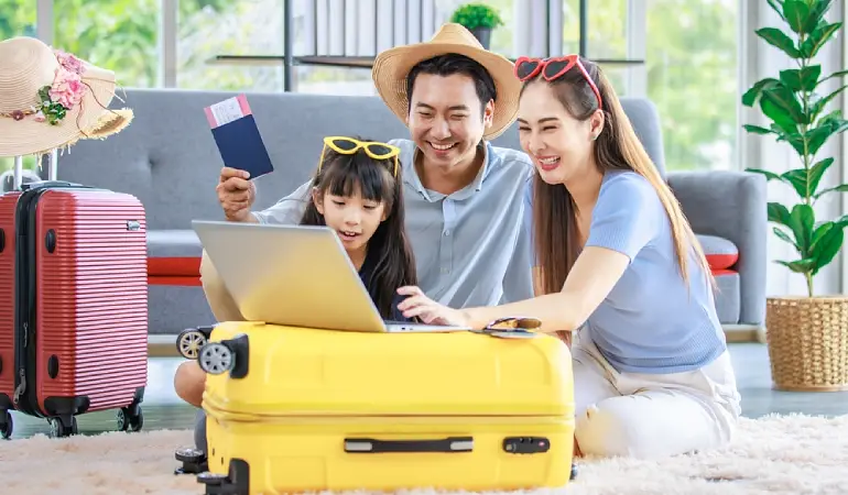 พ่อแม่ลูกกำลังวางแผนเที่ยวครอบครัวในคอมพิวเตอร์โน้ตบุ๊ก