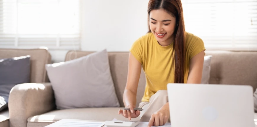 ผู้หญิงที่กำลังคำนวณเงินหลังจากที่ขอสินเชื่อรวมหนี้