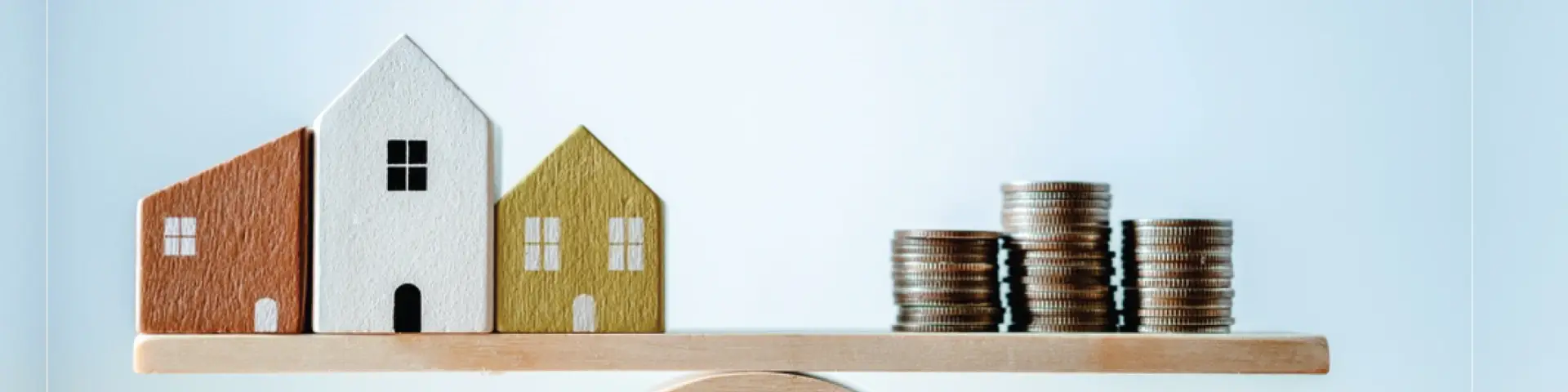 แบบจำลองบ้านและเหรียญบนไม้กระดก สื่อถึงการนำบ้านเข้าธนาคารเพื่อนำเงินมาใช้จ่าย